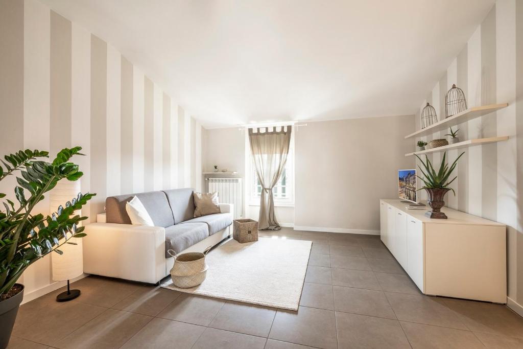 a white living room with a couch and a table at L'Angelica Holiday Home in Desenzano del Garda