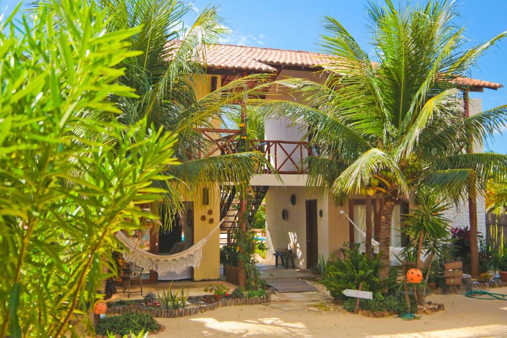 una casa en la playa con palmeras en Pousada Brisamares en Ponta do Anel
