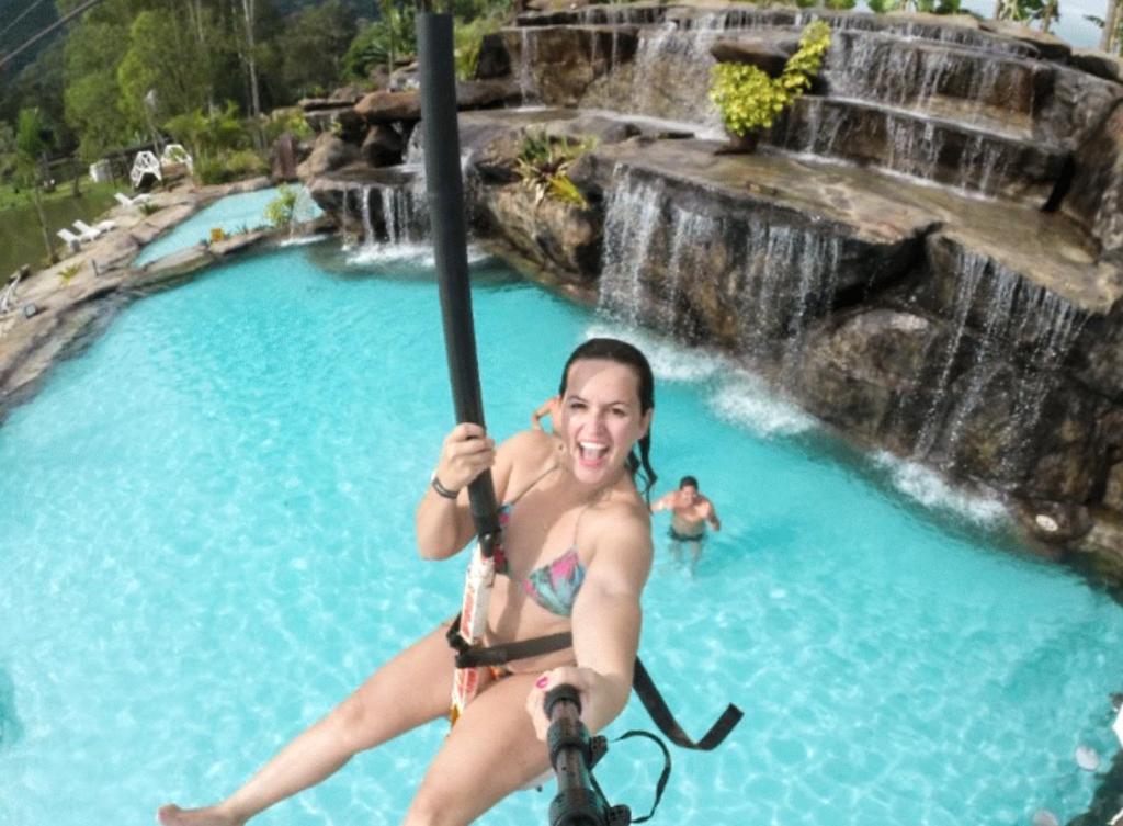 una mujer montando una bicicleta en una piscina en Ganso Complexo de Lazer en Lambari