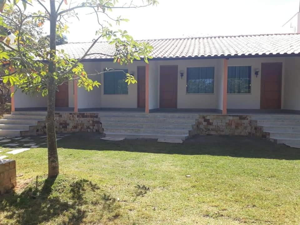 a house with a tree in front of it at RECANTO MARIANE in Santo Antônio do Amparo