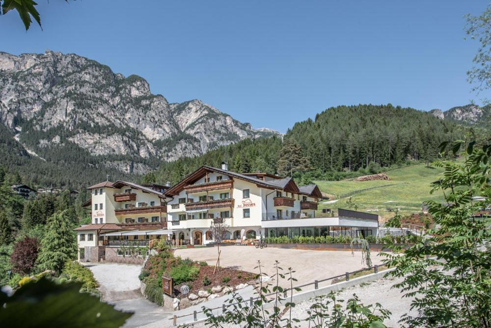 ein großes Gebäude vor einem Berg in der Unterkunft Hotel Dosses in Tiers
