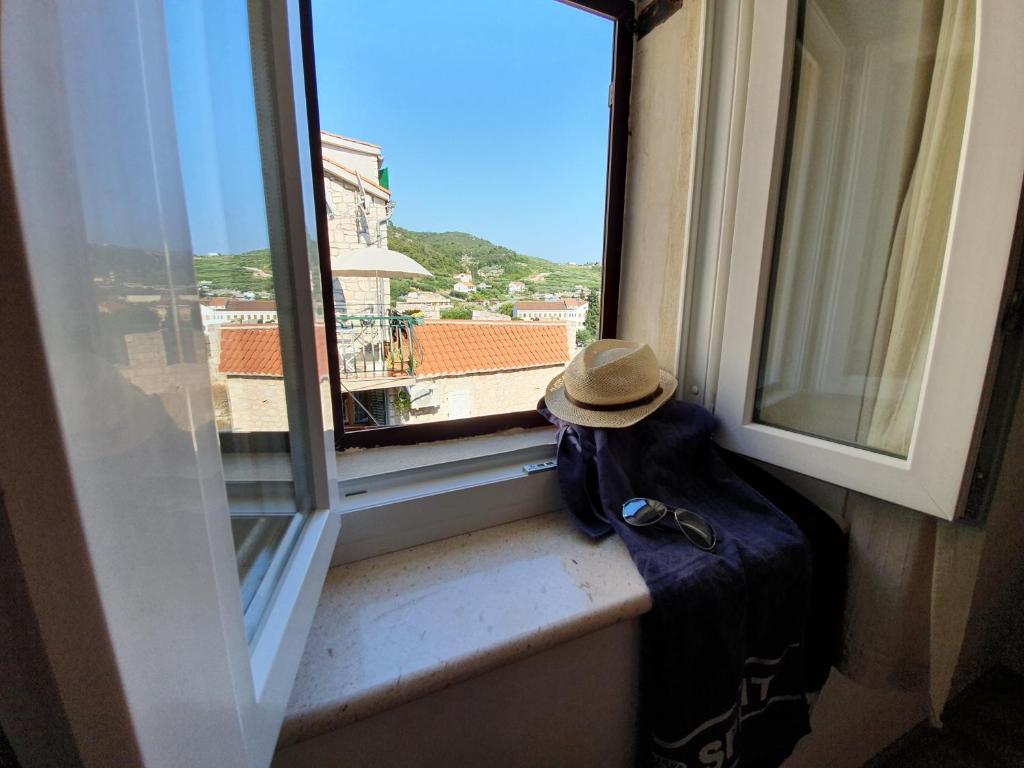 un sombrero sentado en un alféizar de la ventana con vistas en Central Gem - ZF Hvar House, en Hvar