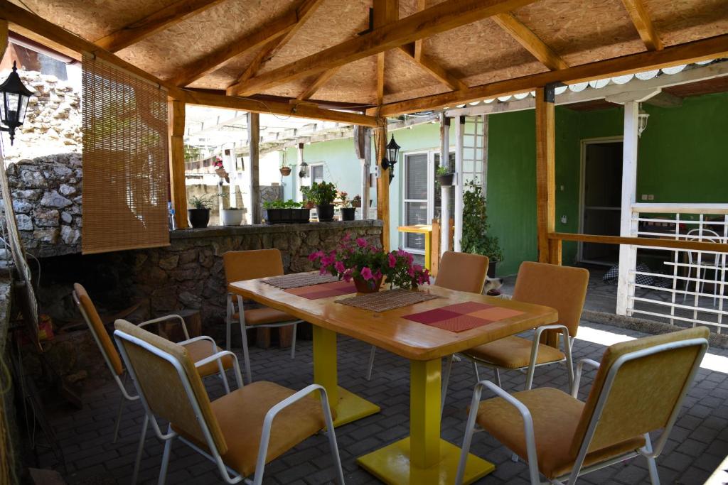 a wooden table and chairs on a patio at Villa In Apartments in Ohrid