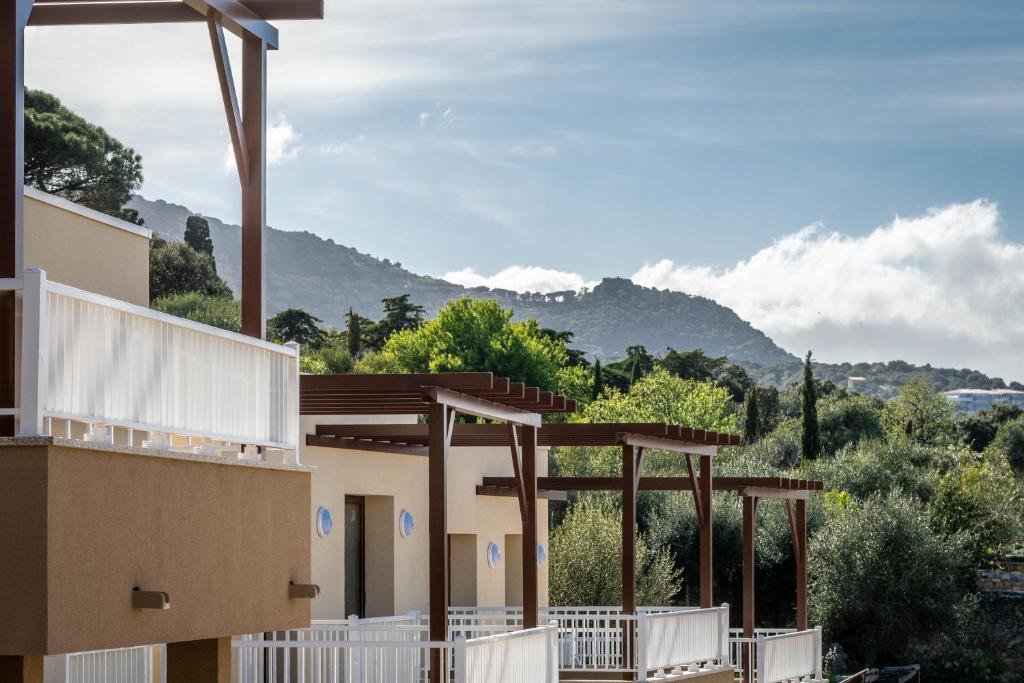 a view of a building with mountains in the background at Domaine A Marella in LʼÎle-Rousse