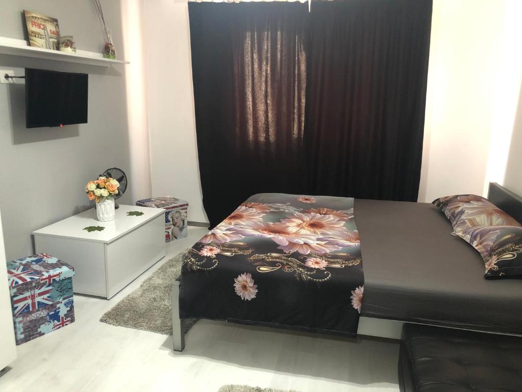 um quarto com uma cama com colcha floral em Garsoniera Aleea Trandafirilor em Băile Herculane
