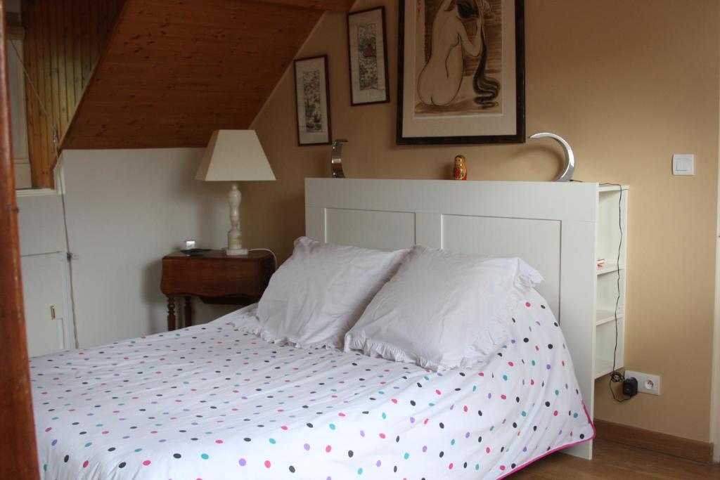 a bedroom with a white bed with polka dot sheets at Le Kiosque Amiens chambres d'hôtes in Amiens