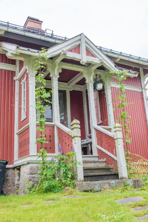 an old red house with a porch and stairs at lunde slusevaktarbolig in Lunde