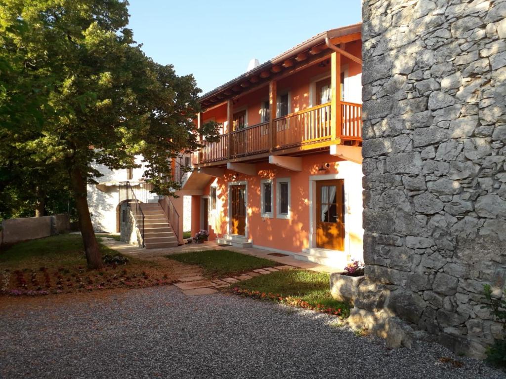a house with a balcony and a stone wall at Agriturismo Kralj in Trieste