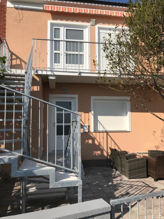 une maison avec un escalier et un balcon dans l'établissement Apartmani Anloma Lorainne, à Povljana