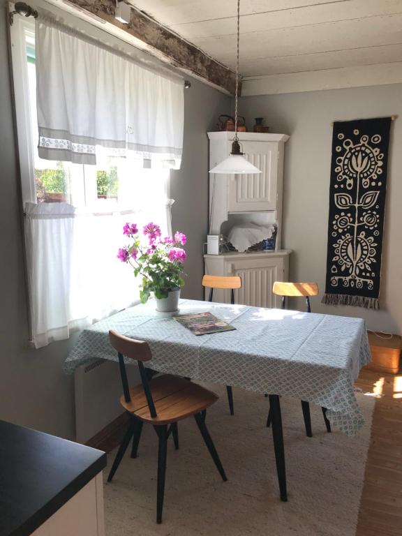 una cocina con mesa, sillas, mesa y flores en Citymökki en Kristiinankaupunki