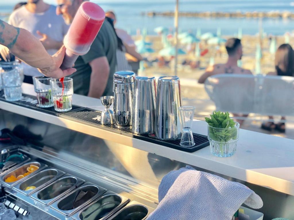 una persona está sosteniendo una taza roja y blanca en Hotel Doge, en Rímini