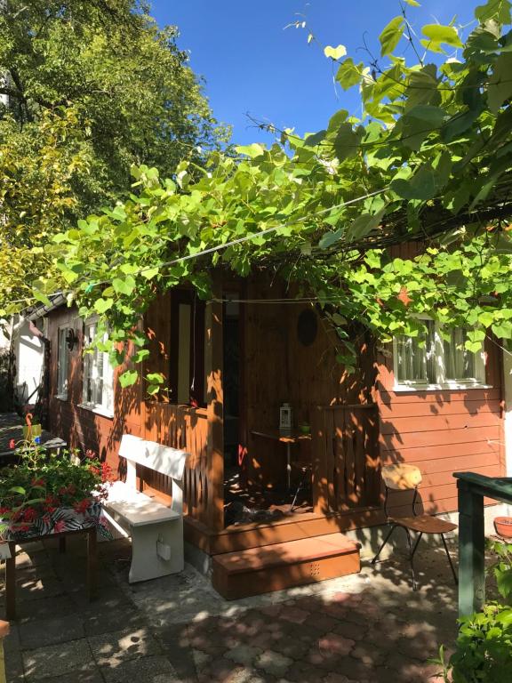 a house with a porch with a bench and trees at Domek Letni Bałtycka in Sopot
