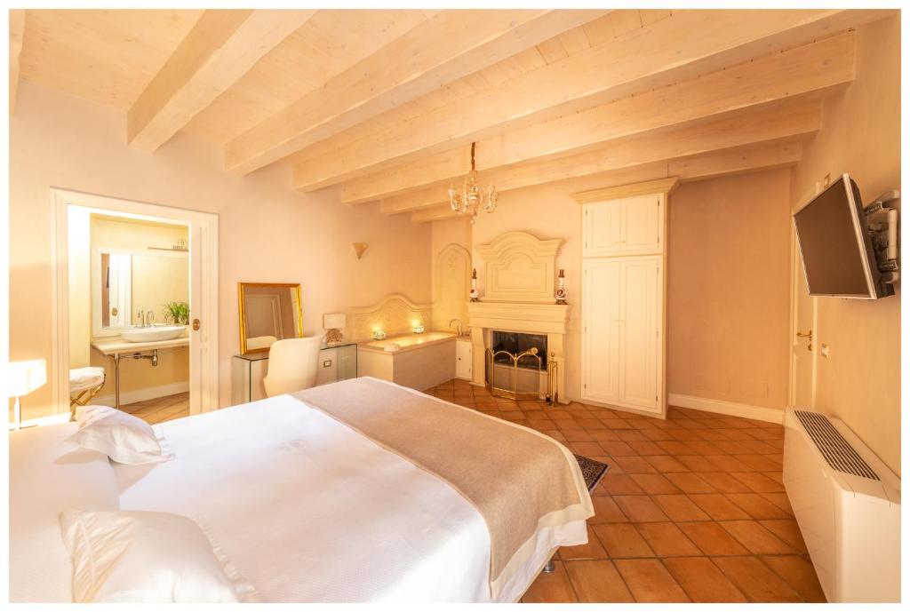 duża sypialnia z białym łóżkiem i kominkiem w obiekcie Boutique - Lodge & Suites w mieście Crotone