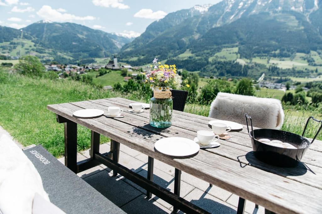 a wooden table with a vase of flowers on it at Ferienwohnung Bognerhof in Sankt Veit im Pongau