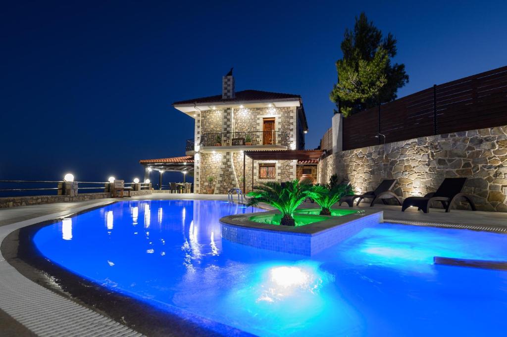 una piscina davanti a una casa di notte di Villa Oneiro Luxury Home ~ Nature, Serenity, View a Ierápetra