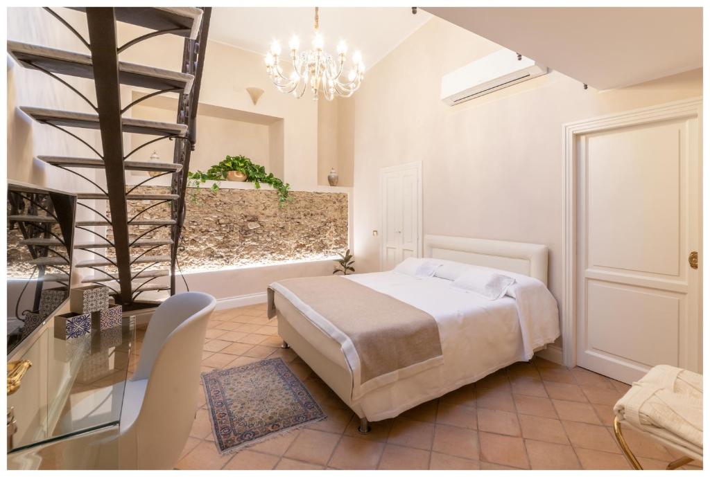 sypialnia z łóżkiem i żyrandolem w obiekcie Boutique - Lodge & Suites w mieście Crotone