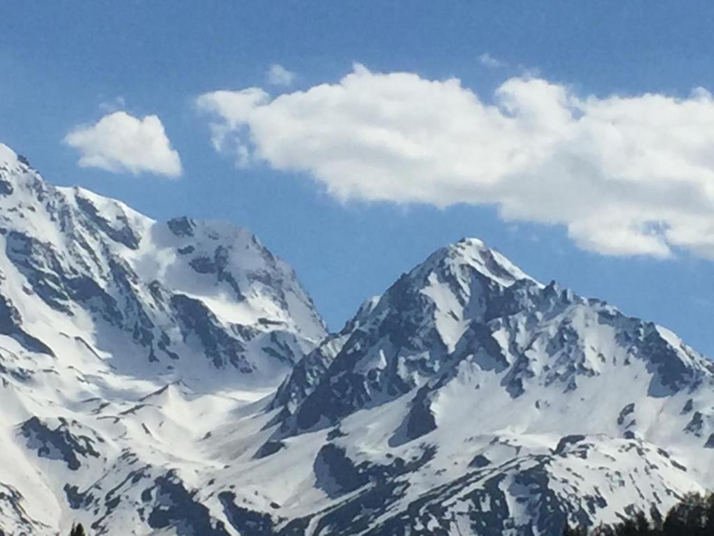 a snow covered mountain range with clouds in the sky at Le petit Saint Bernard in Sainte-Foy-Tarentaise