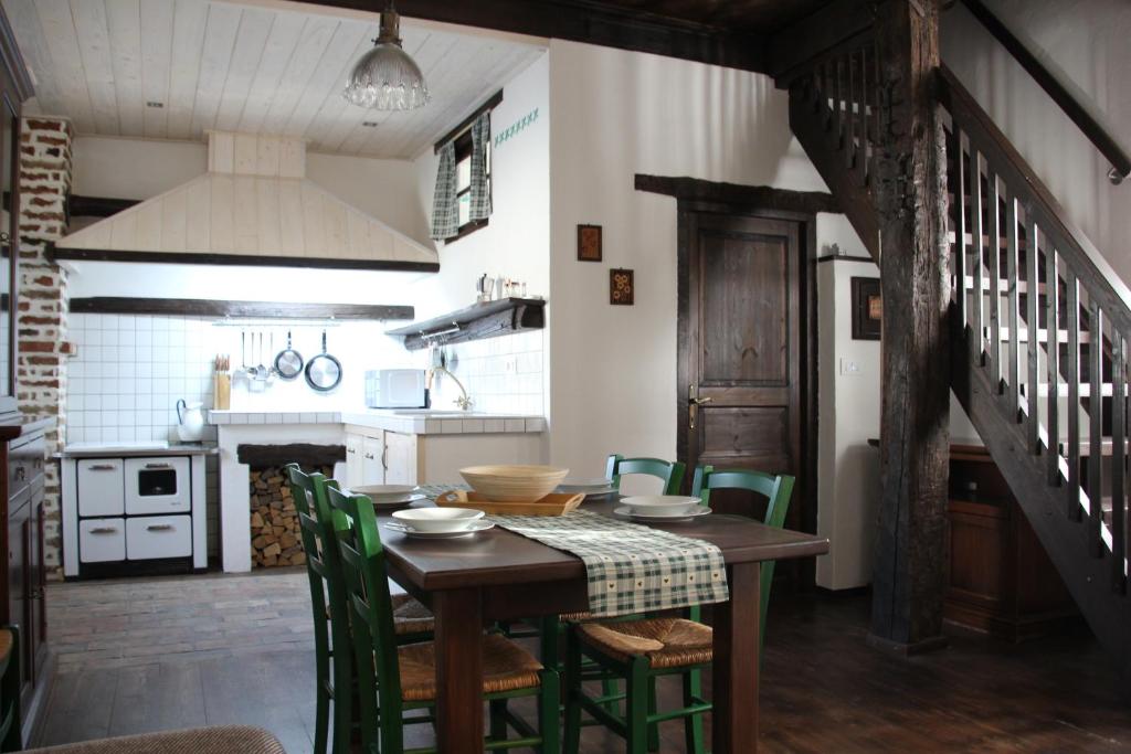 a kitchen with a wooden table and green chairs at Apartma Skednj in Kobarid