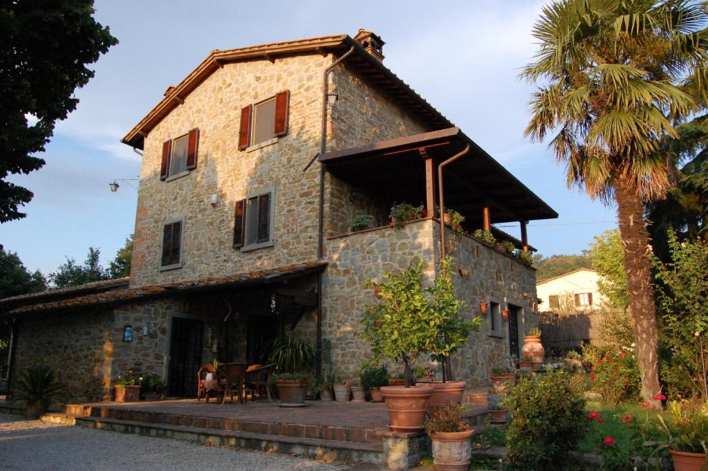 an old stone house with a palm tree at Casa Dina in Terontola