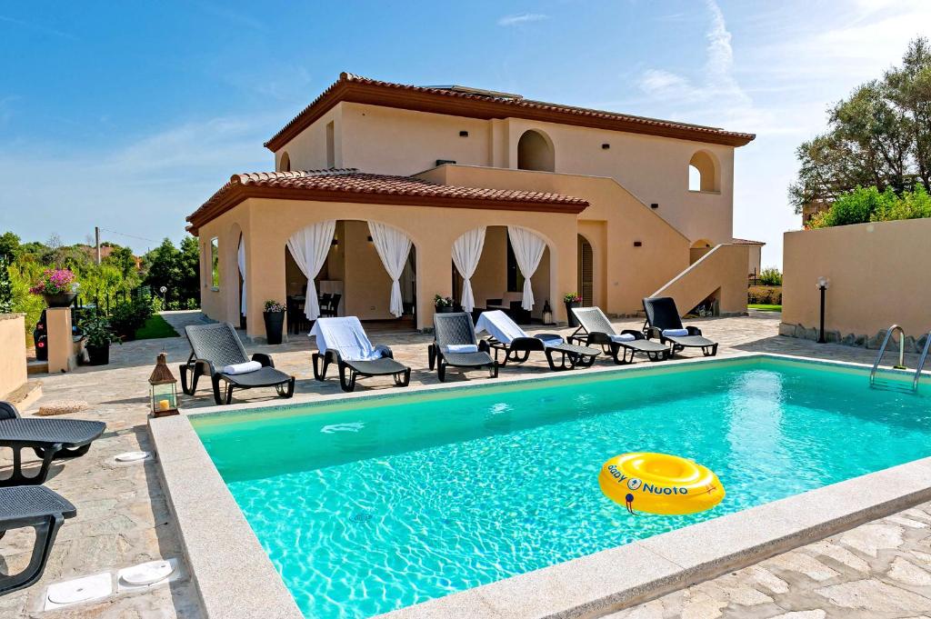 a swimming pool with chairs and a house at MOLAROTTO CAMERE CON ANGOLO COTTURA in San Teodoro