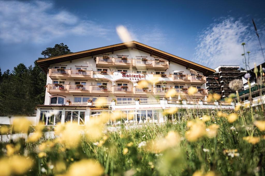 un bâtiment d'hôtel avec des fleurs devant lui dans l'établissement Vitalhotel Kaiserhof, à Seefeld in Tirol