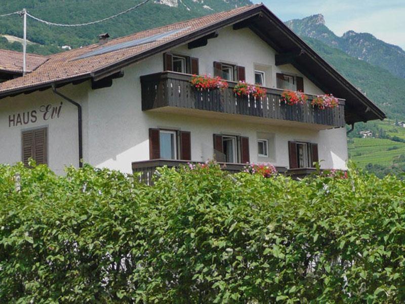 a building with a balcony with flowers on it at Haus Evi in Termeno