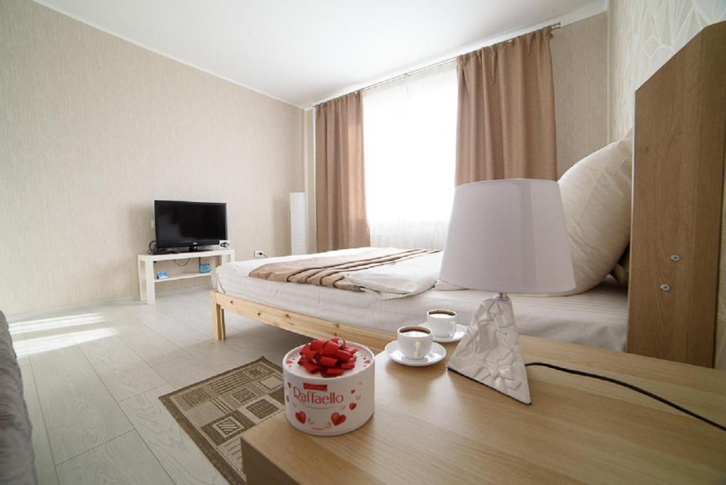 1 dormitorio con 1 cama y 1 mesa con lámpara en PaulMarie Apartments on Kozlova, en Soligorsk