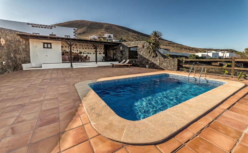 a swimming pool on a patio with a house at Casa Gaida in Tías