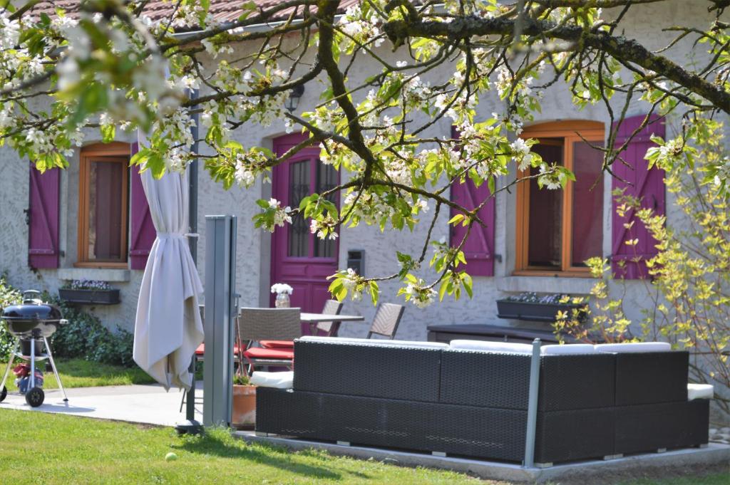 una casa morada con un banco en el patio en Gîte Coeur de Lorraine en Manoncourt sur Seille-Belleau