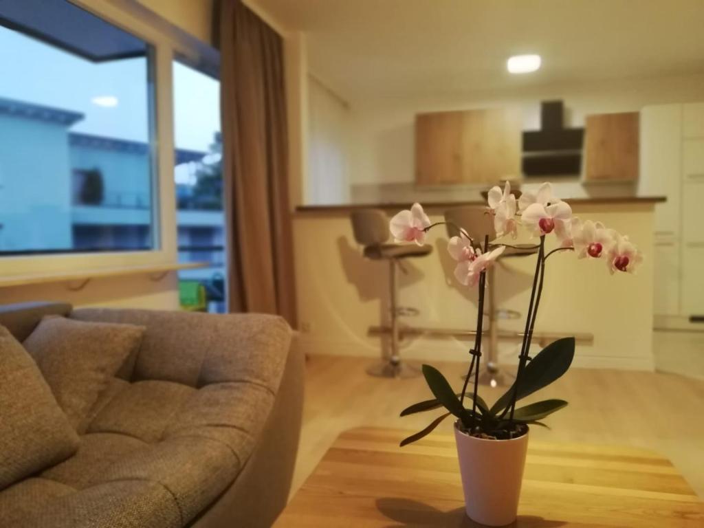 sala de estar con sofá y jarrón con flores en Moscow Areal Suite, en Baden-Baden