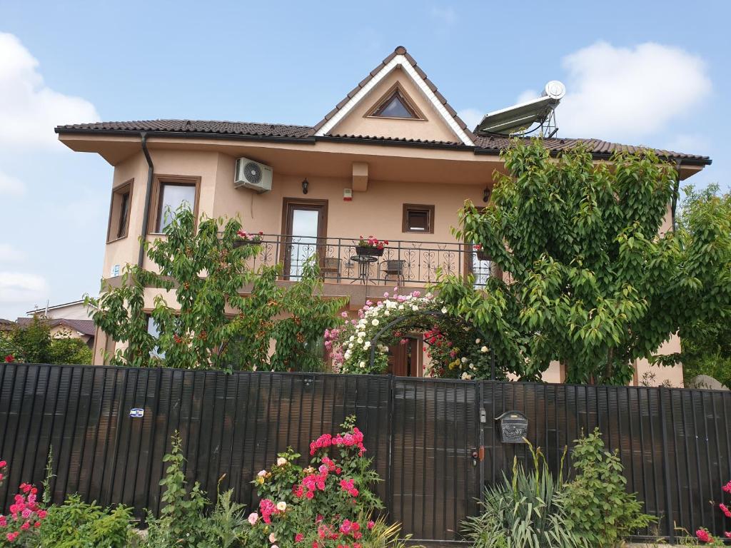 a house behind a fence with flowers at Vila Matei in Techirghiol