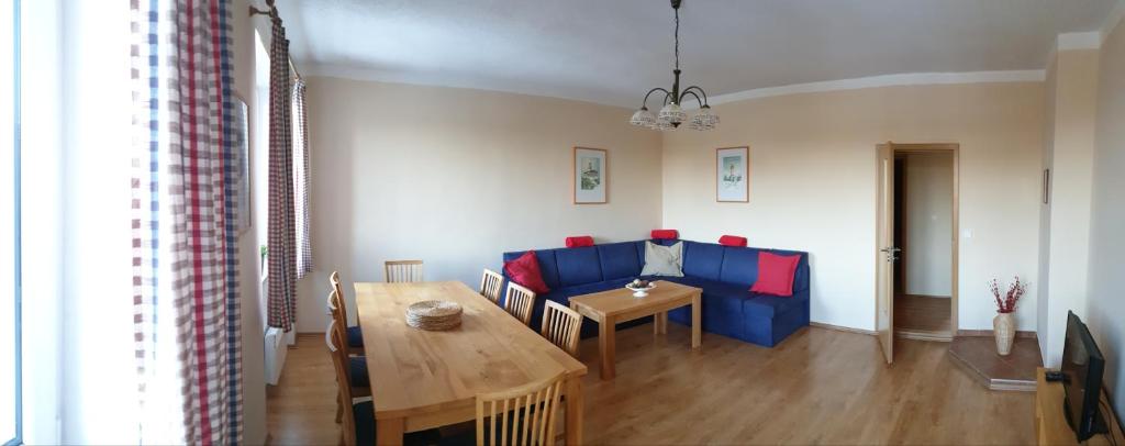 a living room with a blue couch and a table at Apartmán Abertamy in Abertamy