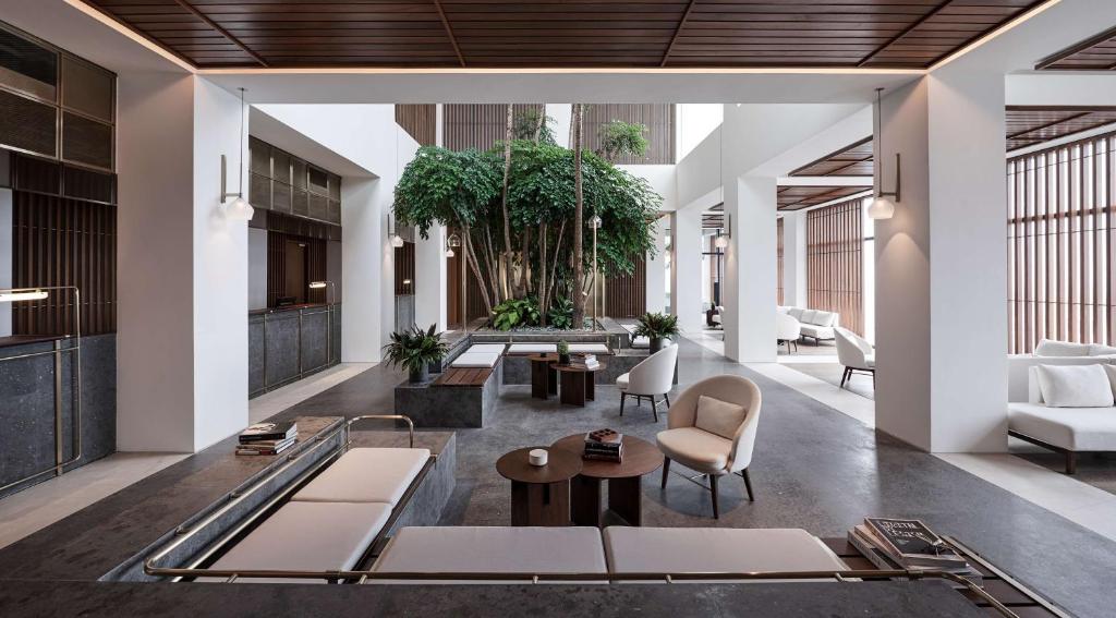 a lobby of a building with chairs and tables at Alila Bangsar Kuala Lumpur in Kuala Lumpur