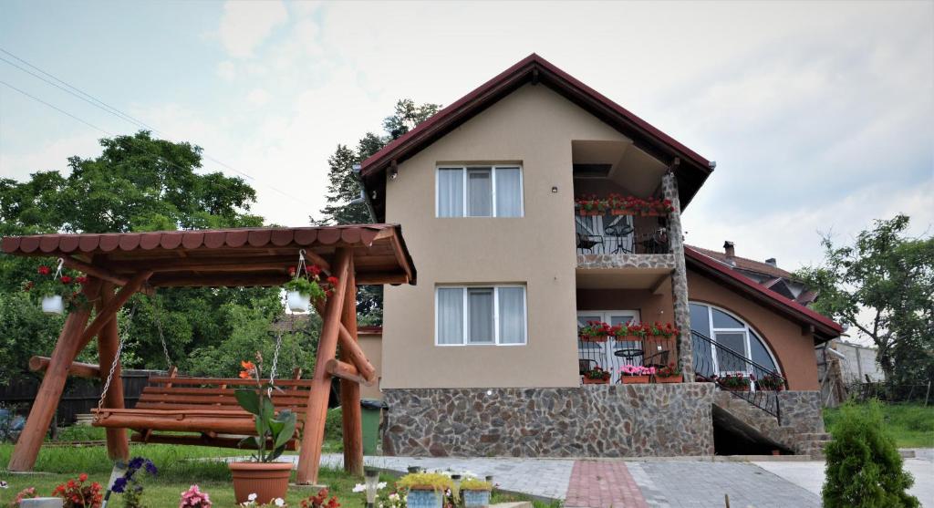 ein Haus mit einer Bank davor in der Unterkunft Bogdan si Raluca in Călimăneşti