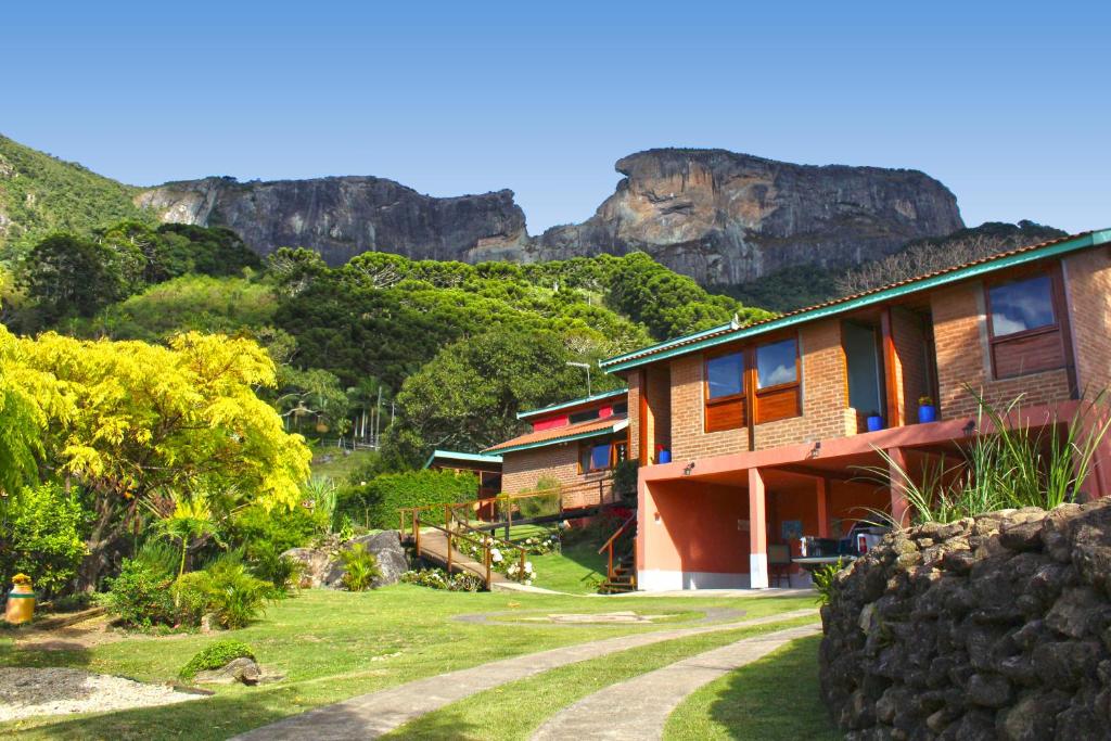 a row of houses with mountains in the background at Hospedaria Estação Píccola No quintal da Pedra do Baú in São Bento do Sapucaí