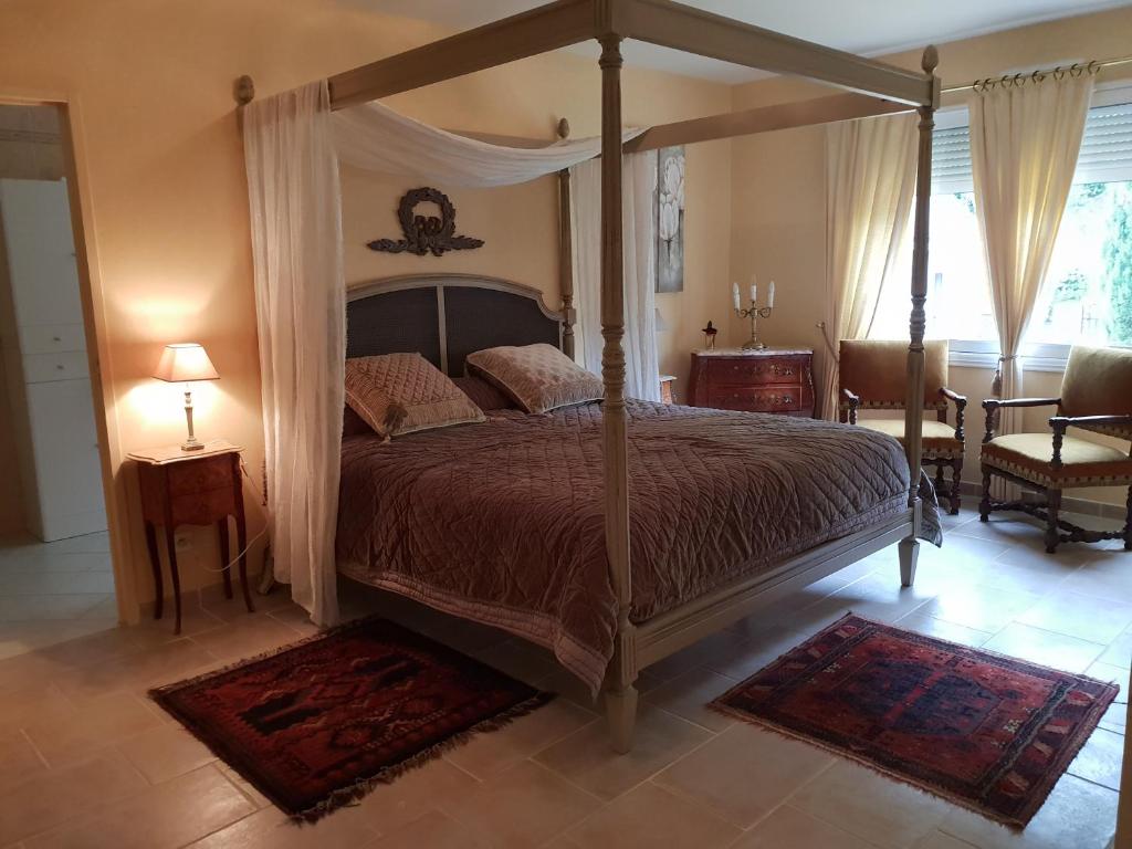 une chambre avec un lit à baldaquin et une table dans l'établissement apartment Fontaine de l'Amour, à Sarlat-la-Canéda