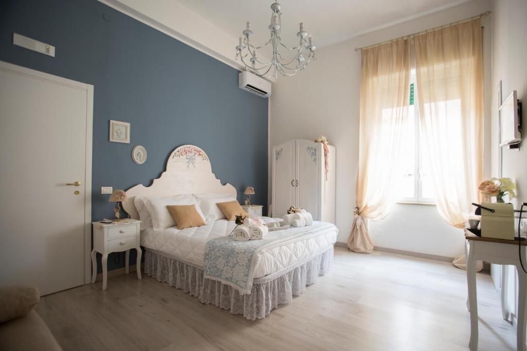 ナポリにあるLa Maison Romantiqueのベッドルーム(白いベッド1台、シャンデリア付)