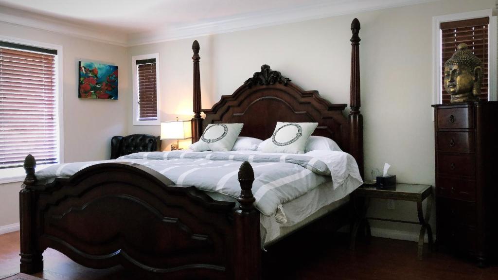 
a bed with a white bedspread and a wooden head board at Royalty B&B in Richmond
