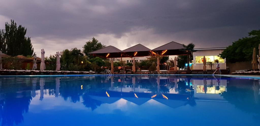 a swimming pool with blue water in front of a building at Cross Apartments and Tours in Yerevan