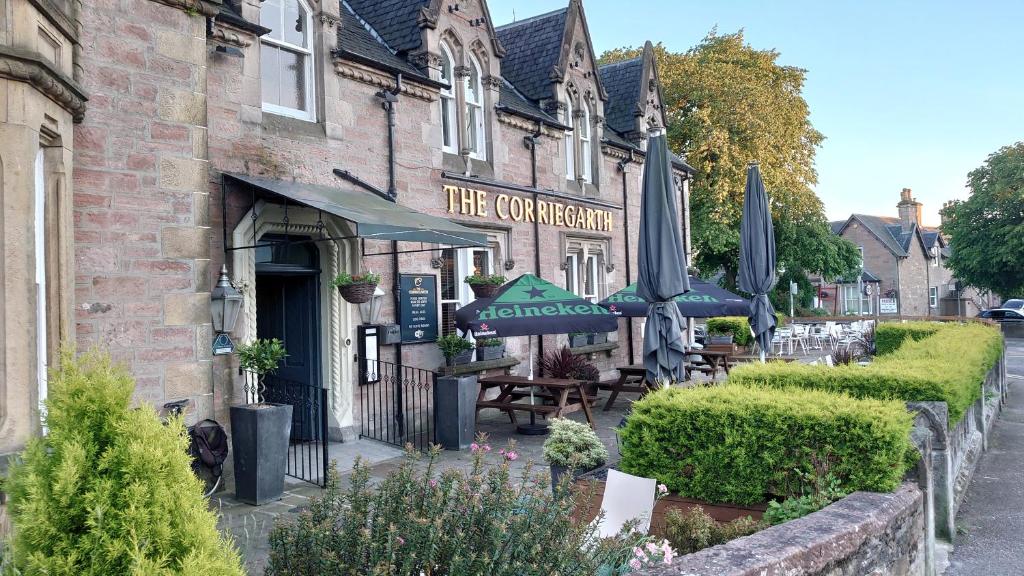 un restaurante con sombrillas frente a un edificio en Corriegarth Hotel, en Inverness