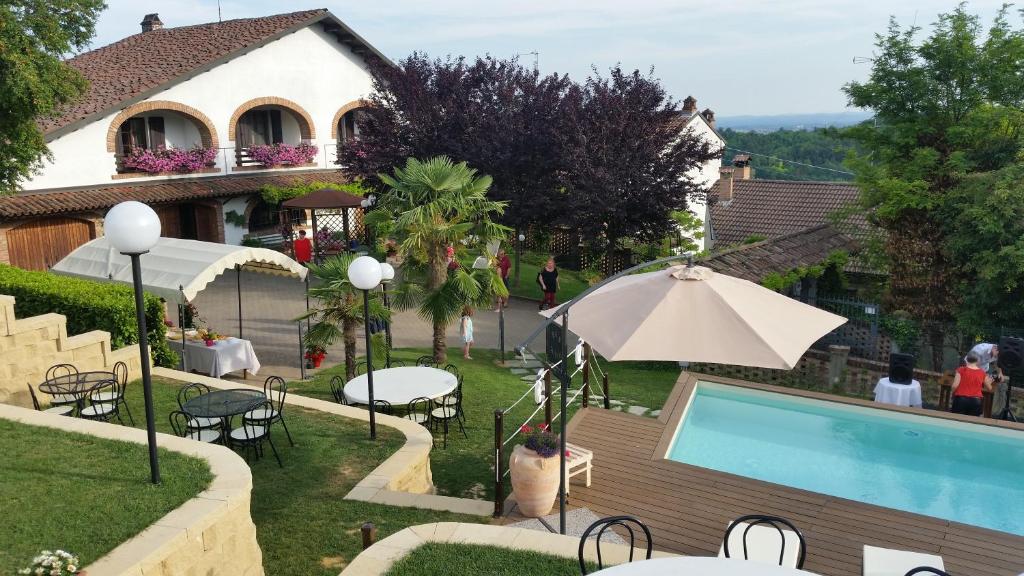 a person sitting under an umbrella next to a swimming pool at Bed And Breakfast Olimpia in San Salvatore Monferrato