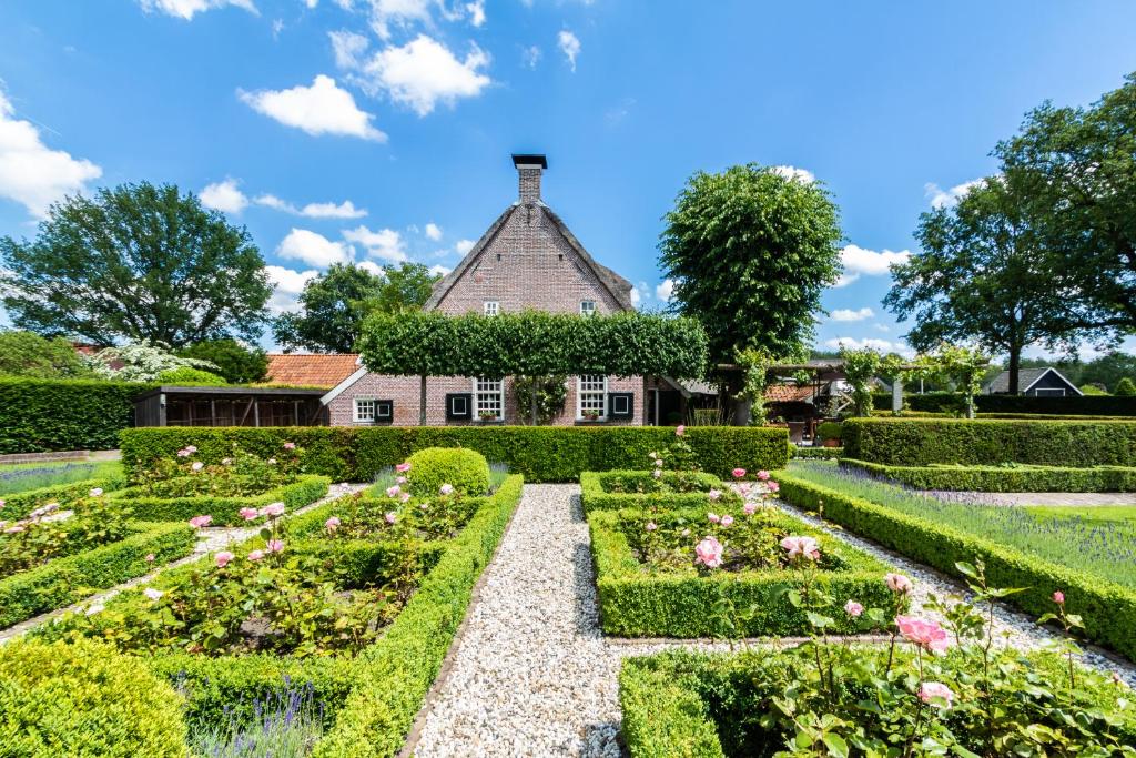 a garden with a house in the background at Hoeve de Eshof in Norg