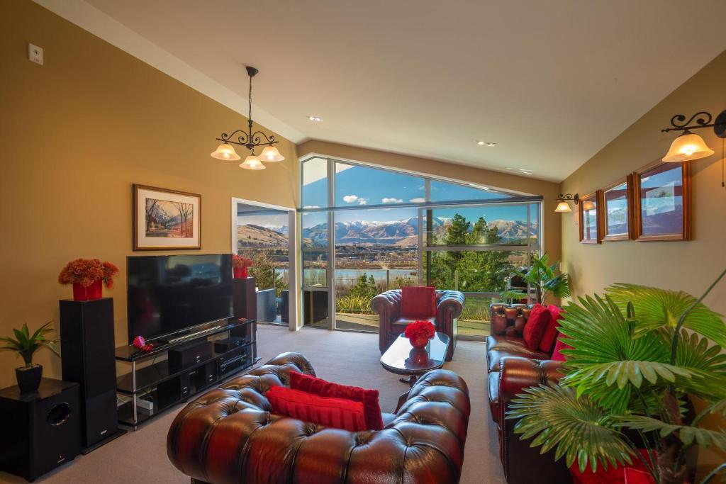 a living room with leather couches and a television at Shotover Ridge in Queenstown
