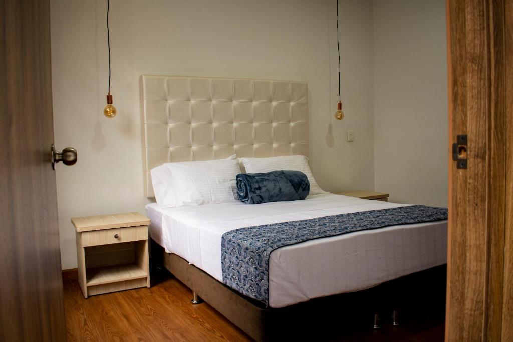 a bedroom with a bed with a blue bag on it at El Reloj Casa Hotel in Filandia