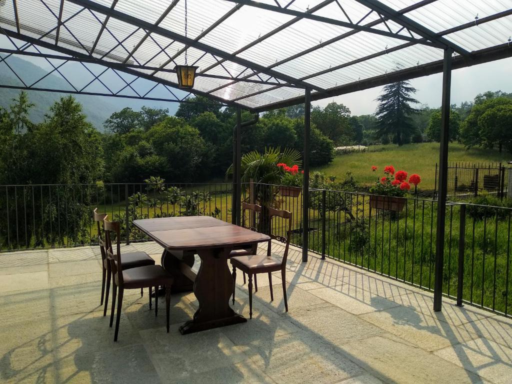 einen Tisch und Stühle unter einer Pergola auf einer Terrasse in der Unterkunft Chez Bonjour in Villar Pellice