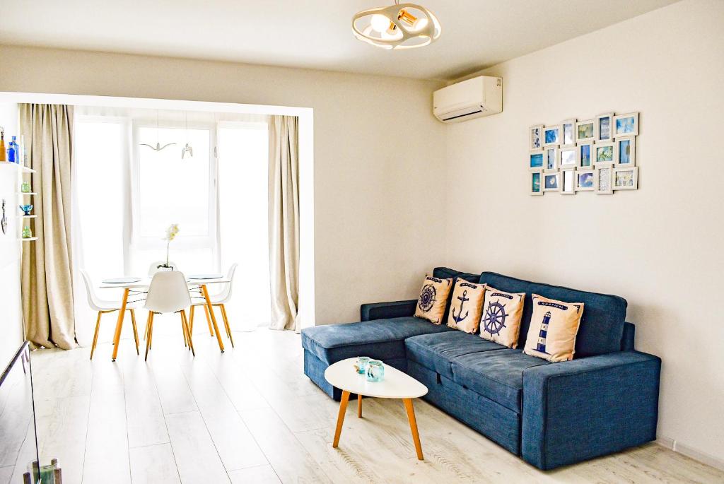sala de estar con sofá azul y mesa en Mediterranean Style Apartment, en Timisoara