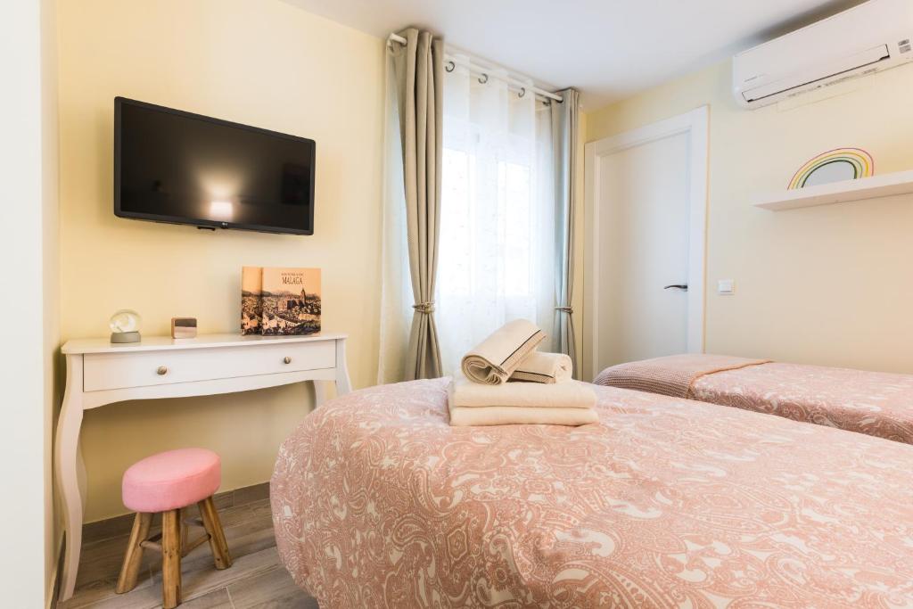 sypialnia z dwoma łóżkami i telewizorem na ścianie w obiekcie Malaga Centre Apartment with Parking w Maladze