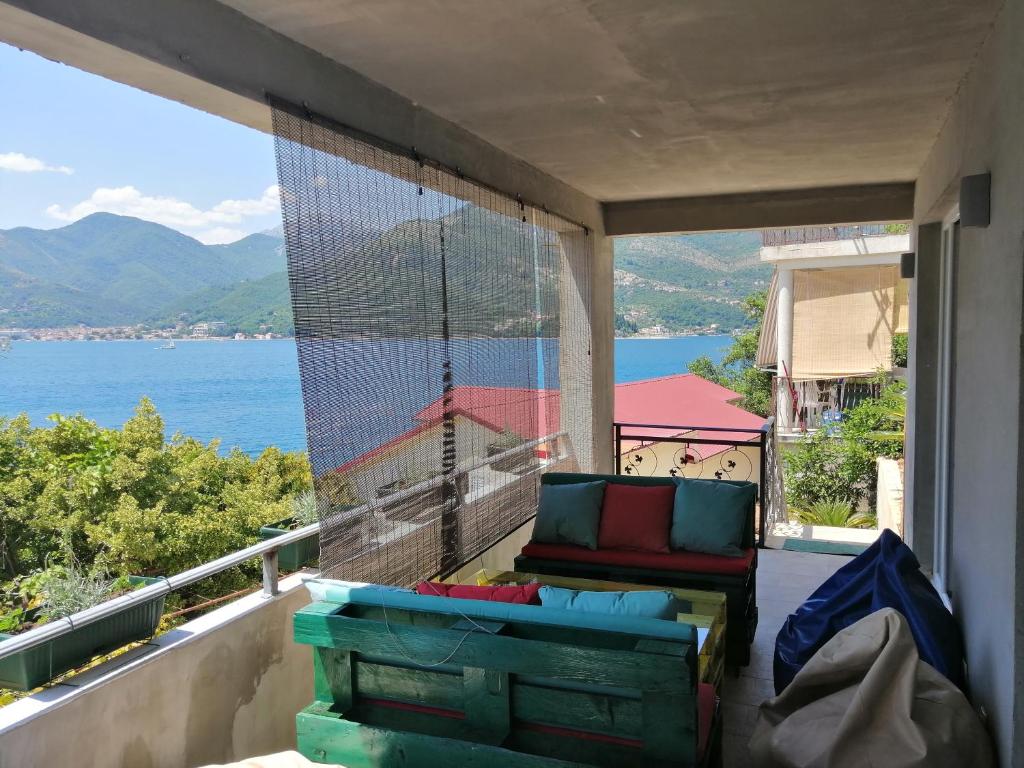 a balcony with a couch and a view of the water at Olive tree apartments in Tivat