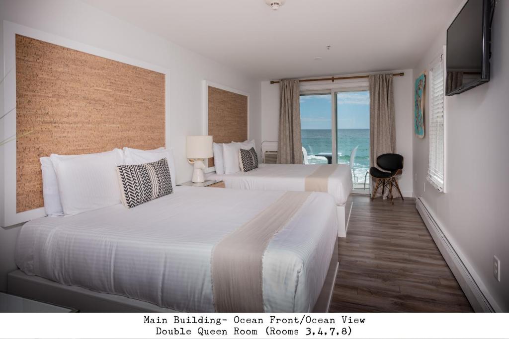 two beds in a hotel room with a view of the ocean at Stones Throw in York Beach
