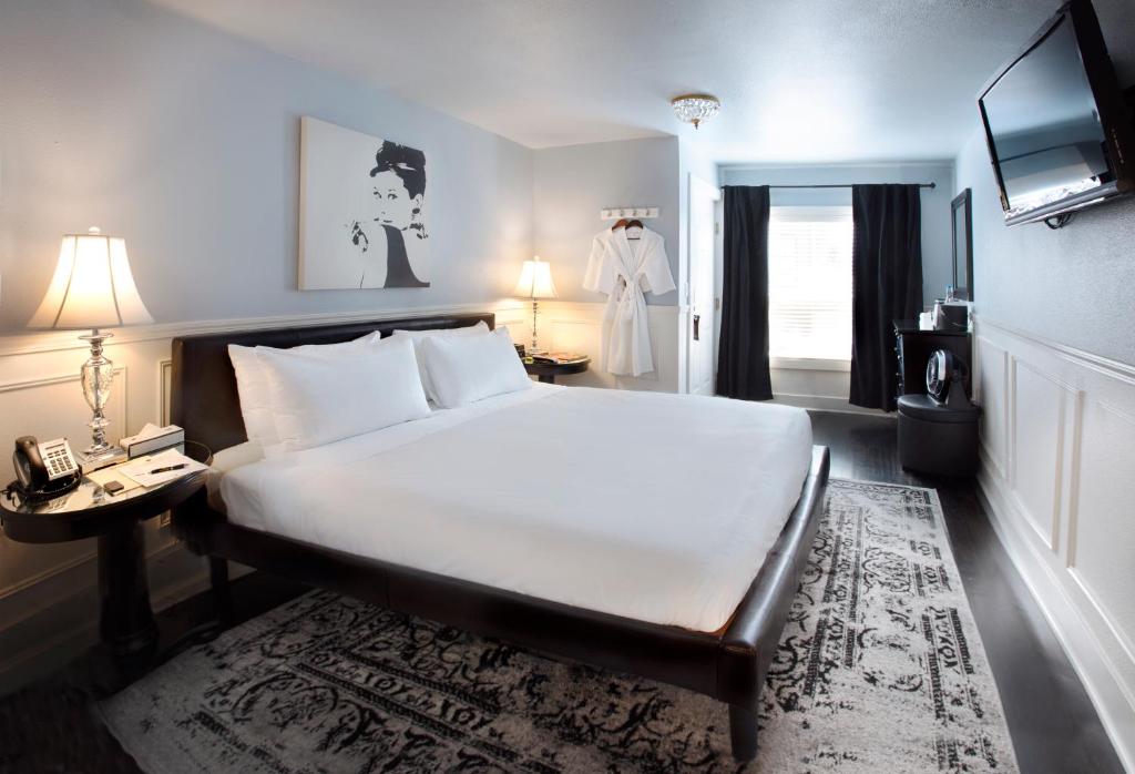 a bedroom with a large white bed and a television at Ballard Inn in Seattle